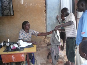 Tailor So many examples going on here! Used pants being fixed up by a tailor who (like all the tailors around here) is using an old singer machine with a pedal so that she can work even when there's no power.