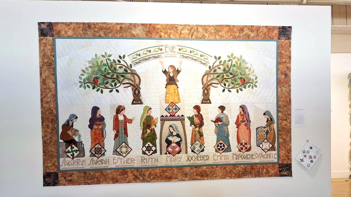 A quilt depicting Eve at the top and various other women in the scriptures below her.